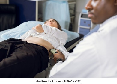 Extracorporeal shockwave therapy in urology. Cropped shot of lying woman patient, having ultrasound diagnostics to determine kidney stones position before the lithotripsy procedure.