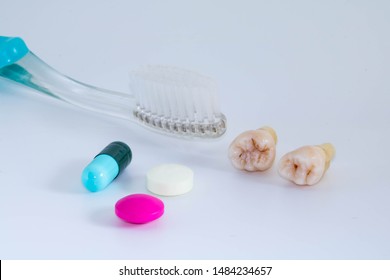 Extracted Impacted Wisdom Teeth With Toothbrush And Medication Set Of Painkiller, Antibiotics, And Disinfectant For Aftercare Surgery In White Background