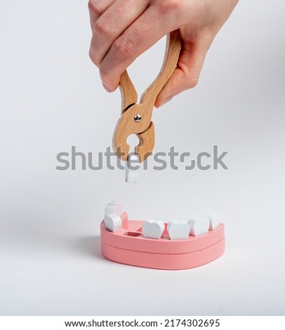 Extracting tooth from jaw model with forceps closeup. High quality photo
