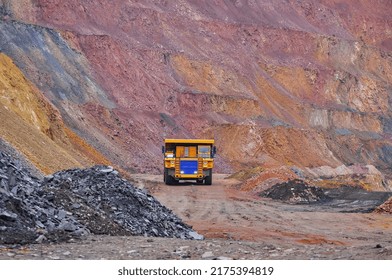 Extraction Of Iron Ore. A Mining Dump Truck Transports Iron Ore Along A Side Carrea. Special Equipment Works In A Quarry	
