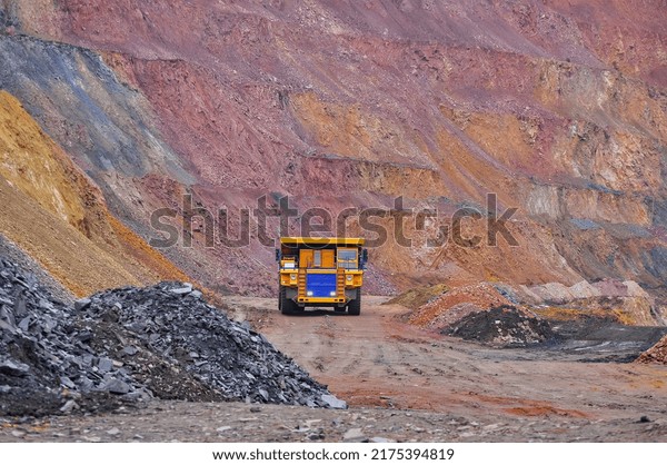 Extraction of iron ore. A mining dump truck\
transports iron ore along a side carrea. Special equipment works in\
a quarry	\
