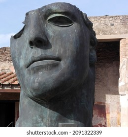 Extraordinary image post modern bronze sculpture figure human face part, Centurione I, Igor Mitoraj exhibition. Art atmospheric installation, scenery immersion in history excavations ancient  Pompeii