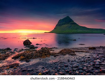 Extraordinary summer sunset with Kirkjufell peak on background. Majestic evening scene of Snaefellsnes peninsula with fall of tide in Atlantic ocean, Iceland. Beauty of nature concept background.