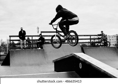 Extreme BMX rider in helmet jump in skatepark on competition. Sport bicycle concept for billboard. Brave and strong man making tricks.