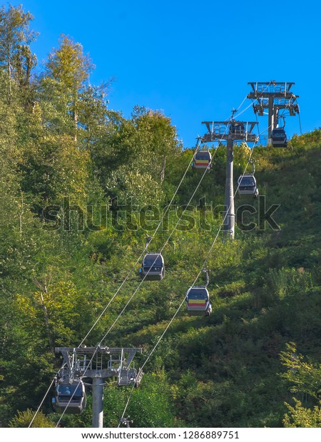 Extreme cable car ride in the mountains. The\
green slopes of the mountains. Summer\
rest.