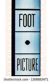 Extreme close up of 35mm movie film strip with foot and pixcture text message