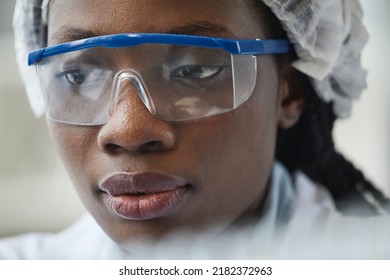 Extreme Close Up Of Black Female Scientist Wearing Protective Glasses In Lab