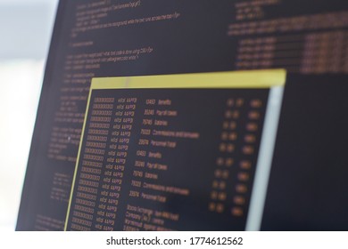 Extreme close up of black and orange programming code on laptop screen, IT and software development concept, copy space