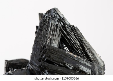 Extreme close up of black tourmaline mineral isolated over white background in focus stacking technique