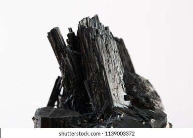 Extreme close up of black tourmaline mineral isolated over white background in focus stacking technique