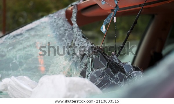 Extreme close up of car
with broken windshield, Car crash accident damaged windshield
triplex is broken on white car, nature of dent resembles an
accident involving
pedestrian.