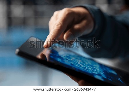 Extreme close up of data center developer using device to do AI algorithms improvements. Programmer in server hub using tablet, maintaining databases supporting AI driven applications.