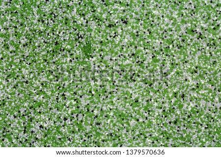 Extreme close up of decorative quartz sand epoxy floor or wall coating with green, grey, white and black coloured particles