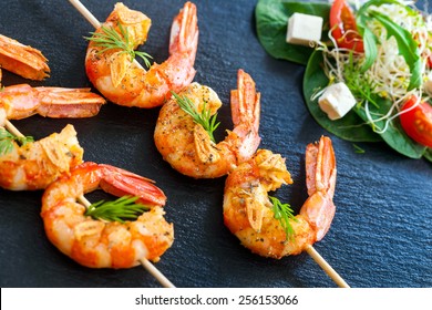 Extreme close up of grilled queen prawn brochettes spiced with natural herbs.