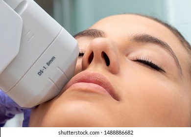 Extreme Nahaufnahme einer HIFU-Behandlung im weiblichen Gesicht. Therapeut, der mit hochintensivem fokalen Ultraschallgerät kosmetische Plasmaspitzenlift betreibt.