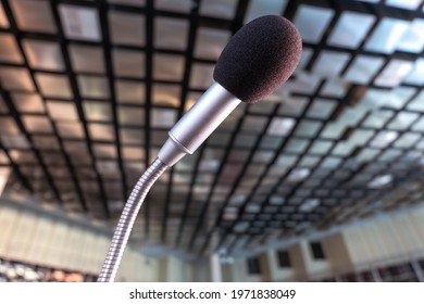 
Extreme Close Up From A Low Wide Angle View Of A Microphone In A Conference Room, Boardroom Or Lecture Hall, Selective Focus
