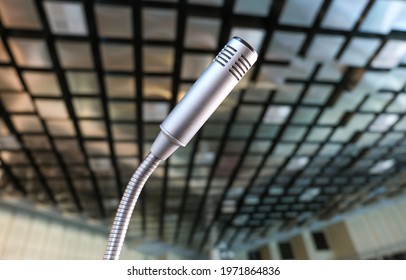 

Extreme Close Up From A Low Wide Angle View Of A Microphone In A Conference Room, Boardroom Or Lecture Hall, Selective Focus 