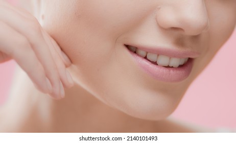 Extreme Close-up Of Beuty Woman's Face With Smooth Healthy Skin, Hand Touching Jawline On Pink Background | Skincare And Face Care Commercial Concept