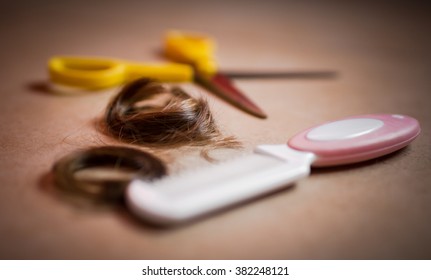 Extreme close-up of a comb, hair and cutting shears.