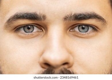 Extreme close-up macro portrait of face. Young adult handsome bearded man's eyes looking at camera. Gray green eyes of guy male boy. Caucasian man opening blinking eyes, smiling. Laser correction - Powered by Shutterstock