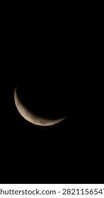 Extreme close-up macro view of a sharp crescent moon glowing against a pure black pitch-night sky background