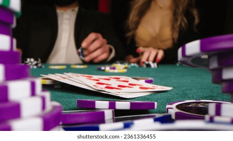 Extreme close-up of poker cards, player checking his hand before making bet. Casino customer playing at table, winning combination strategy, gambling fortune. Lucky tournament winner looking at pair