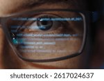 Extreme close-up of a programmer or software engineer eye with computer code reflecting on glasses, symbolizing cybersecurity, coding, and artificial intelligence development. Data science concept