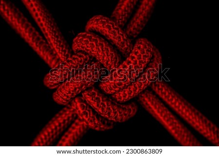 Extreme Closeup of Red Colored Knotted Rope with Black Colored Background 