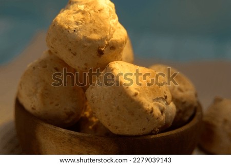 Extreme Close-Up of Rustic Chipa Bread in Natural Wooden Bowl: Highlighting the Irresistible Crusty Texture and Nutty Aroma of This Traditional South American Snack, Served in a Handcrafted Bowl Made 