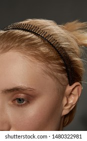 Extreme Close-up Shot Of A Young Blonde European Girl With A Black Hairband Made In The Form Of A Spiral Spring Twining Around The Wire In Her Hair. The Fashion Model With Nude Make-up Is Looking Away