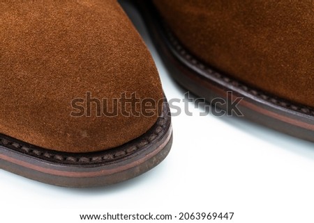 Extreme Closeup of Texture of Toes of Brown Suede Mens Shoes Over White Background. Horizontal Shot