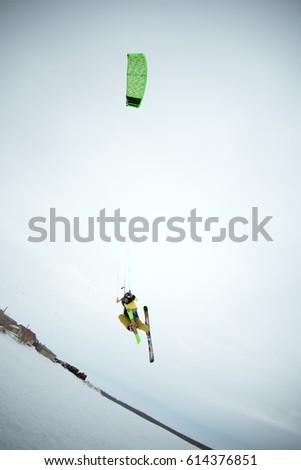 extreme freestyle ski jump with young man at winter season on the background of blue sky . snowkiting.