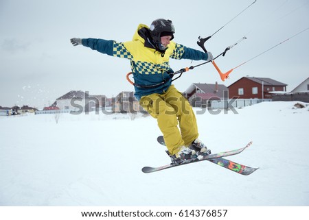 extreme freestyle ski jump with young man at winter season on the background of blue sky . snowkiting.
