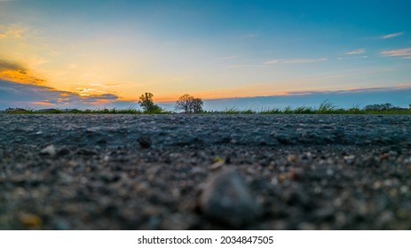 Extreme Low Angle Sunset In Dramatic Sky Over Asphalt Road. High Quality Photo