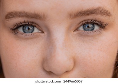 Extreme macro close-up portrait of face. Young adult beautiful pretty woman's eyes looking at camera. Blue eyes of teen girl female. Caucasian woman wide opening eyes, smiling. Laser correction. - Powered by Shutterstock