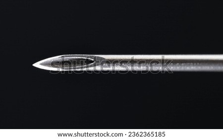 Extreme macro close-up of a sterile pristine 22 gauge medical needle bevel, showcasing its razor-sharp tip