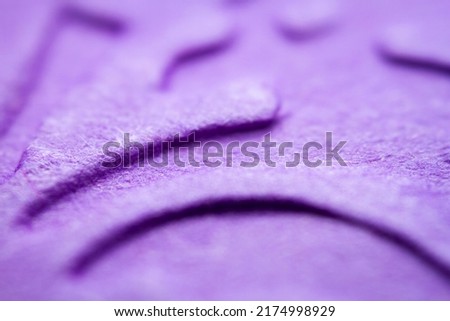 Extreme macro of embossed purple paper. Selective focus, shallow depth of field.