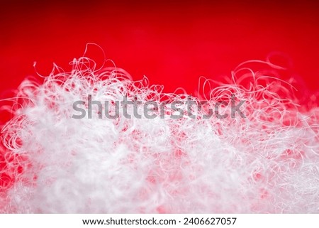 Extreme macro of polyester stable fiber on red background. Selective focus, shallow depth of field. Abstract dreamy background