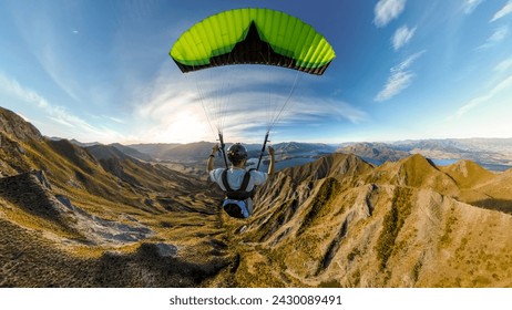 Extreme paraglider pilot flying over Wanaka, New Zealand. Adventure concept. - Powered by Shutterstock