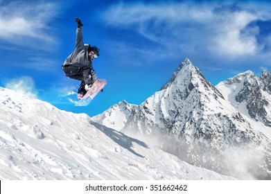 Extreme snowboarding man. Snowboarder jumping high in the air