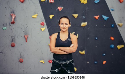 Extreme sport, climbing, people and healthy lifestyle concept - fit woman posing with crossed arms at indoor climbing gym, looking at camera. - Powered by Shutterstock