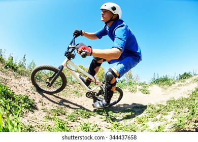 Extreme Sport Concept. Young Cyclist Riding The Mountain Bike Uphill Or Cross-country Course