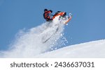 Extreme sport race snowmobiles. Snowmobile in high jump above track. Sportsman on snowmobile. Trick against blue sky. Snow motor sports Copy space.