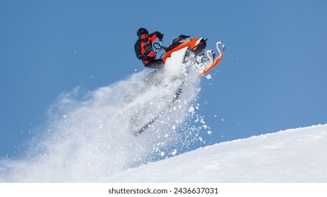 Extreme sport race snowmobiles. Snowmobile in high jump above track. Sportsman on snowmobile. Trick against blue sky. Snow motor sports Copy space.