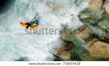An extreme whitewater Kayaker paddling on the Emerald waters of Soca river, Slovenia, are the rafting paradise for adrenaline seekers and also nature lovers, aerial view.
