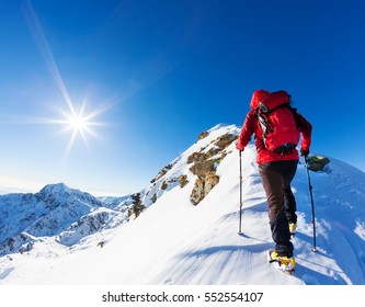 Extreme winter sports: climber at the top of a snowy peak in the Alps. Concepts: determination, success, brave.
