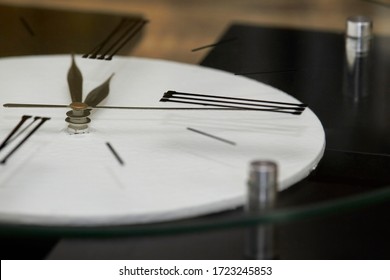 Extremely close-up black clock hands on a white dial, selective focus