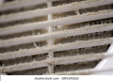 Extremely dirty air ventilation grill of HVAC with dusty clogged filter, close up, macro. Cleaning and disinfecting is required to prevent dust allergies and other lung illnesses and diseases.