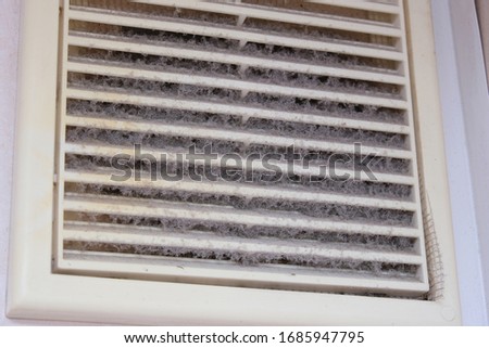 Extremely dirty and dusty white plastic ventilation air grille at home close up, harmful for health, house cleaning concept..