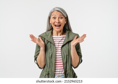 Extremely happy amused mature middle-aged caucasian woman in casual clothes and grey hair feeling shock impression, hearing good news, sale, discount, offer isolated in white background